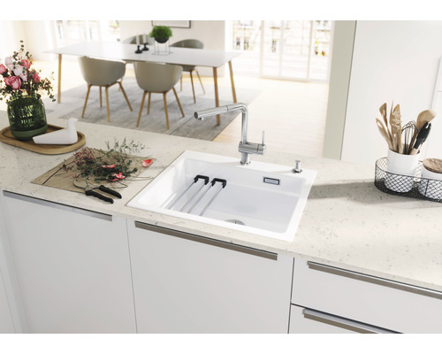 Évier de cuisine avec égouttoir, robinet et distributeur de savon dans une cuisine claire