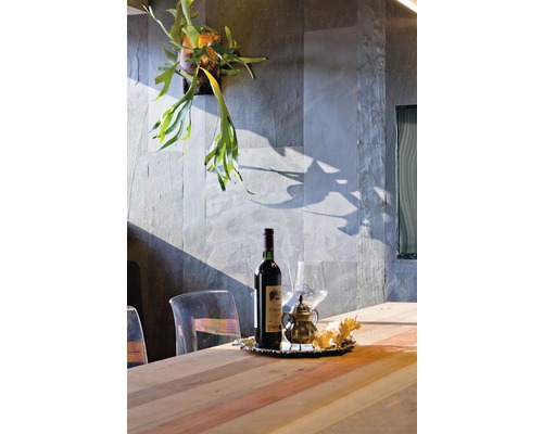 Arrangement décoratif avec bouteille de vin, verre, pot et plantes sur une table à manger