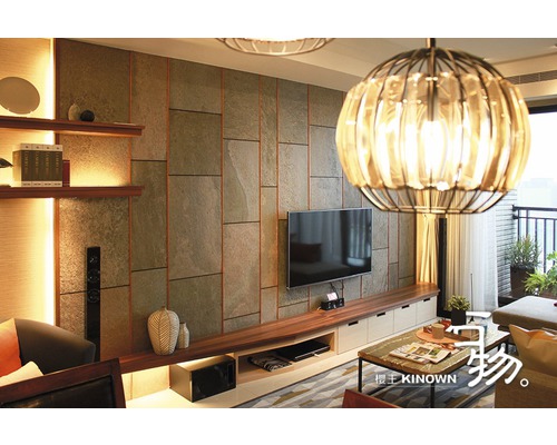 Wohnzimmer mit Steinwand, Regalen, TV-Gerät und Pendelleuchte