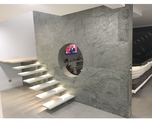 Treppe mit Beleuchtung und Wandverkleidung mit runder Öffnung in einem Zimmer