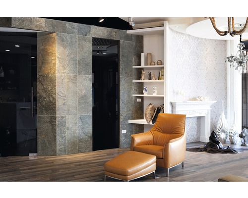 Wohnzimmer mit Fliesenwand, Sessel und Dekoration