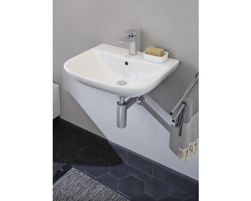 Vasque en céramique avec robinet et porte-serviettes dans la salle de bain