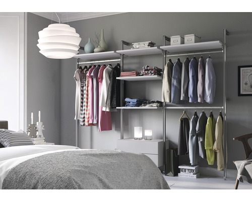 Chambre avec dressing en métal et parquet, ainsi que des vêtements sur des cintres