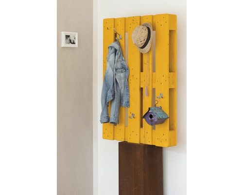 Panneau de garde-robe en palette jaune avec veste, chapeau et nichoir