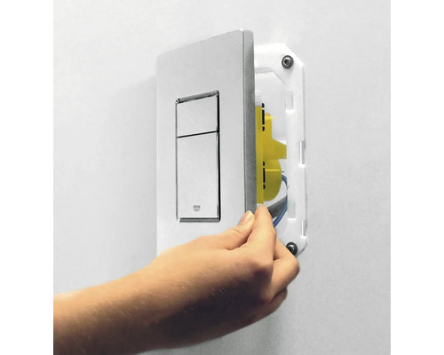 Une plaque de commande pour les toilettes est montée au mur.
