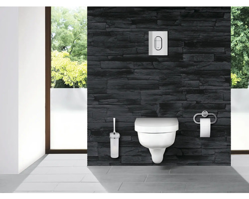 Modernes Badezimmer mit wandhängendem WC, Betätigungsplatte, WC-Bürste und Toilettenpapierhalter vor einer Steinwand