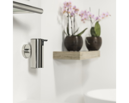 Distributeur de savon mural en acier inoxydable dans la salle de bain.