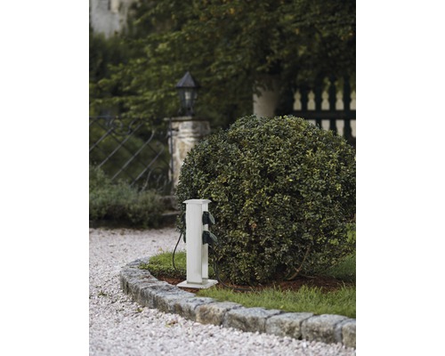 Colonne de distribution électrique à l''extérieur, à côté d''un buisson