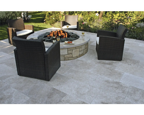 Scène de jardin avec foyer, dalles de pierre et fauteuils en osier