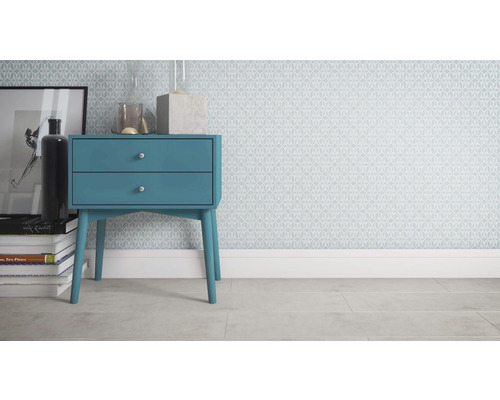 Chambre décorative avec table de chevet bleue, livres et papier peint à motifs