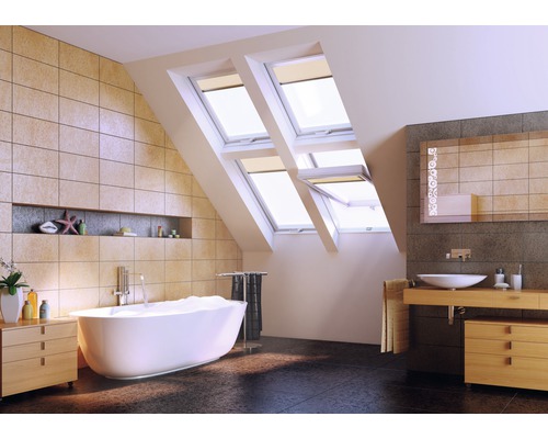 Salle de bain lumineuse avec baignoire, fenêtres de toit et lavabo