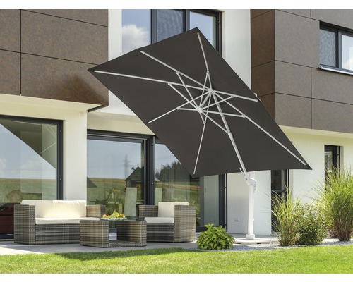Parasol carré avec mât latéral et ensemble de sièges en rotin sur une terrasse.