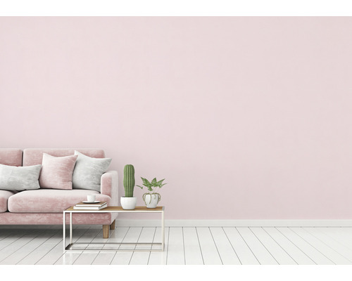 Salon rose avec canapé, coussins, table et plantes