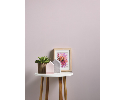 Scène décorative avec une plante en pot, des décorations pour la maison et une impression florale encadrée sur une petite table.