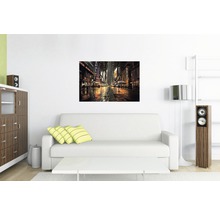 Salon avec canapé, table et une image murale avec un motif de ville de nuit