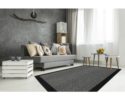 Salon avec canapé gris, coussins, table en bois, tapis gris et décoration