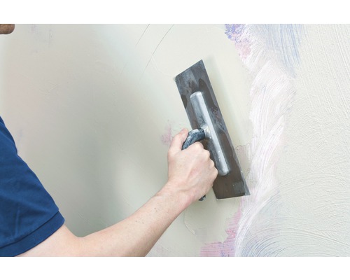 Handwerker glättet eine Wand mit einer Glättkelle