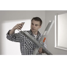 Un homme assemble un profilé de construction sèche avec une équerre de montage