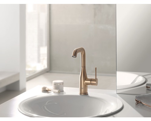 Un robinet doré est posé sur un lavabo.