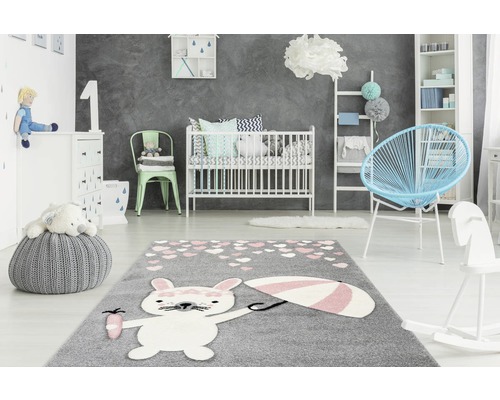 Kinderzimmer mit grauem Teppich mit Hasenmotiv, Kinderbett und Möbeln