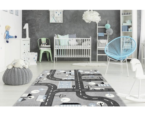 Kinderzimmer mit grauem Teppich mit Straßenmuster, Babybett und Kindermöbeln