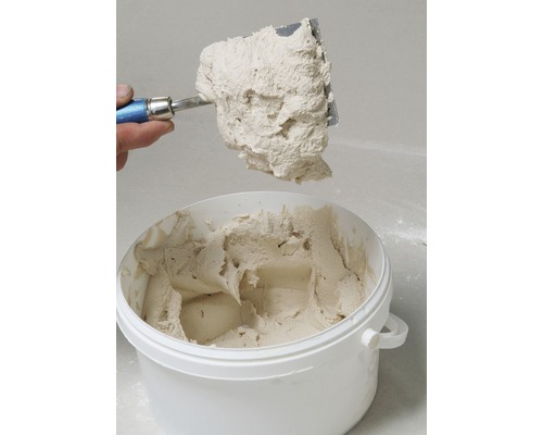 Mastic dans un seau avec un couteau à mastic