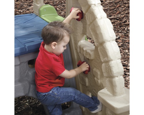 Kleinkind klettert an einer Kletterwand aus Kunststoff auf einem Spielplatz