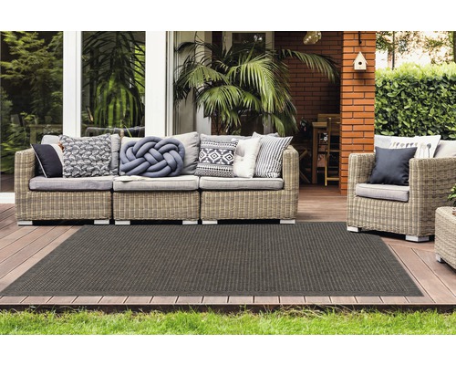 Terrasse avec ensemble de canapés en rotin et tapis foncé