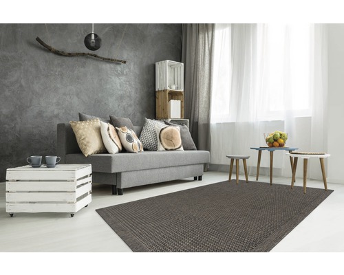 Salon avec canapé gris, coussins, table basse en caisses en bois, tapis et éléments décoratifs