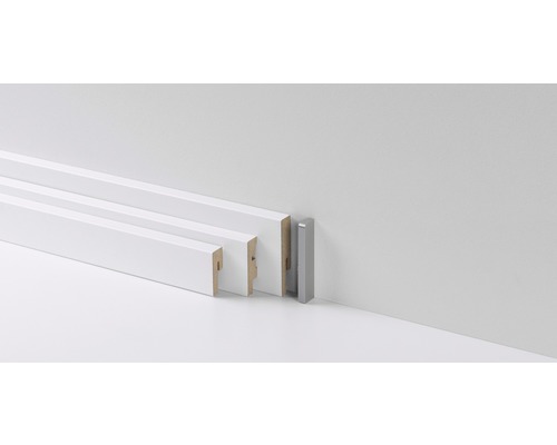 Diverses plinthes blanches et une plinthe argentée devant un mur