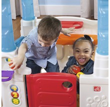 Deux enfants jouent avec une maisonnette Step2.