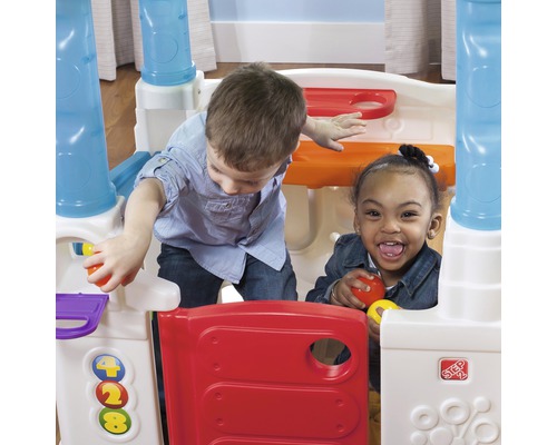 Deux enfants jouent avec une maisonnette Step2.