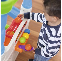 Un enfant joue avec un circuit à billes avec des balles colorées.