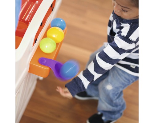Enfant jouant avec un jouet à balles avec des balles colorées et une pelle