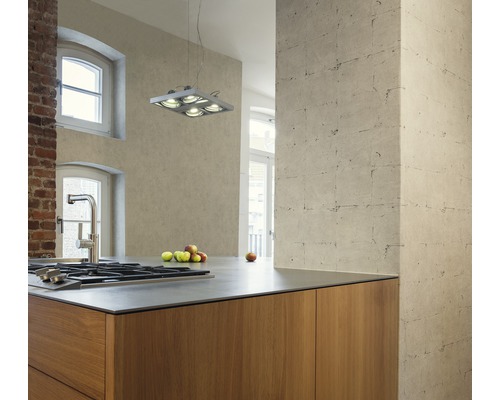 Cuisine claire avec îlot de cuisson, plafonnier et mur en briques