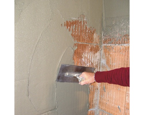 Auftragen von Putz auf eine Wand mit einer Glättkelle