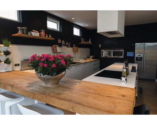 Cuisine lumineuse avec plan de travail en bois, îlot de cuisine, murs noirs et décorations