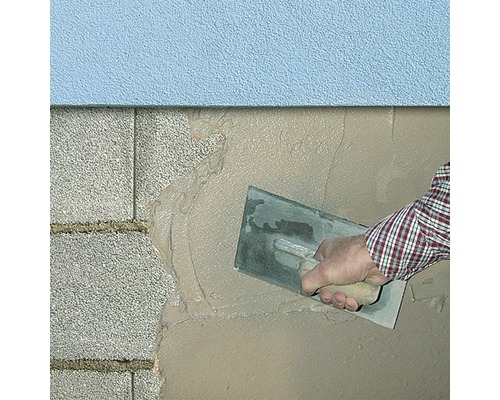 Auftragen von Putz auf eine Wand mit einer Kelle.