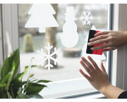 Aufbringen von Fensterfolie mit Wintermotiven mit Rakel