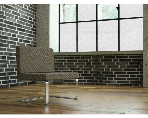 Scène avec une chaise à pieds métalliques devant un mur de briques et une fenêtre.