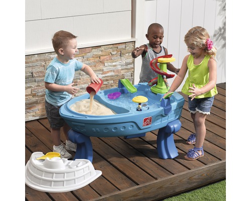 Des enfants jouent avec une table à sable et à eau Step2 à l''extérieur.