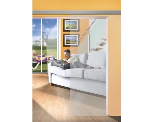 Salon avec porte coulissante en verre, canapé et homme lisant