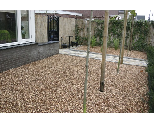 Gestalteter Garten mit Kiesweg und Bambuszaun