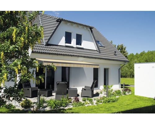 Façade de maison avec store et mobilier de jardin sur la terrasse