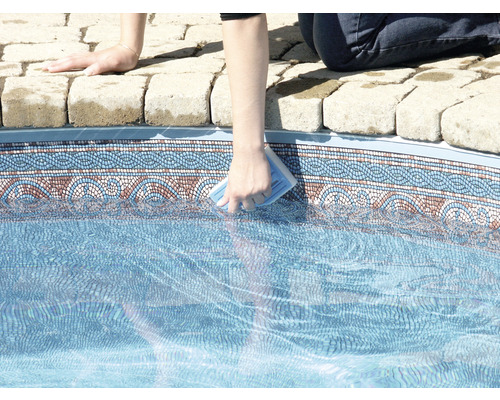 Une personne nettoie une piscine avec une éponge de nettoyage.