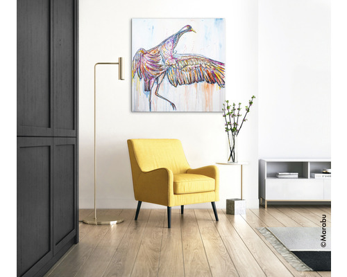 Salon avec fauteuil jaune, lampadaire et tableau d''un oiseau au mur
