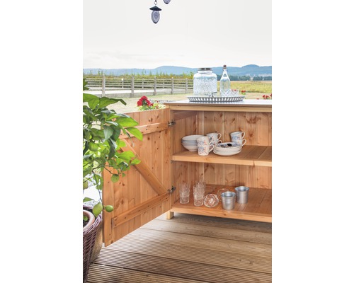 Holzschrank mit Geschirr und Gläsern im Außenbereich.