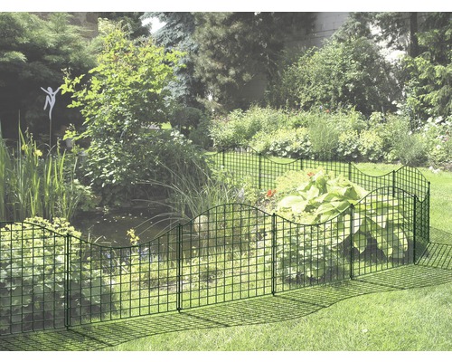 Garten mit einem niedrigen Drahtzaun, der ein Blumenbeet umgibt