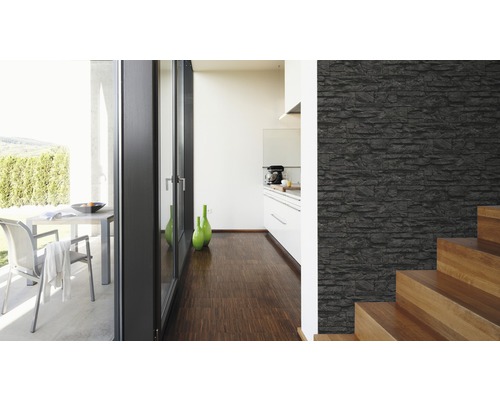 Pièce lumineuse avec un mur aspect pierre, escalier et vue sur une terrasse