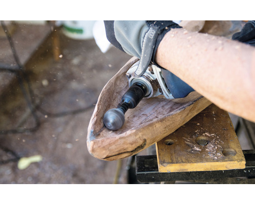 Ein Handwerker bearbeitet eine Holzschale mit einem Kugelfräser.